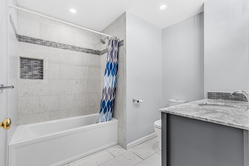 121 Shade Street Lexington, MA 02421 - Photo 31 of 42 a bathroom with a granite countertop sink mirror toilet and bathtub
