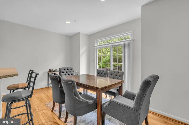 a view of a dining room with furniture a rug and wooden floor