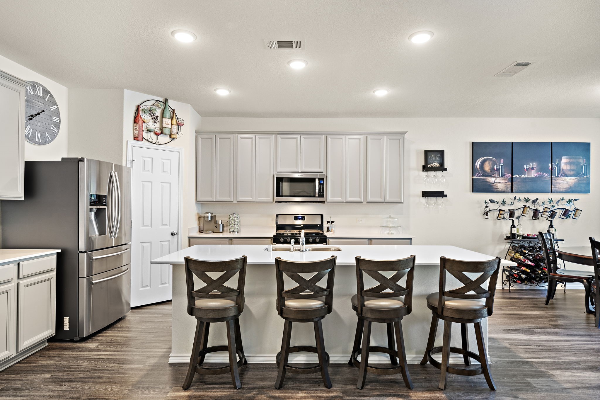 4210 Amber Ruse Drive Conroe, TX 77304 - Photo 14 of 45 This modern kitchen features stainless steel appliances, a large island with seating for four, and ample cabinetry. The open layout and bright lighting create a welcoming space for cooking and entertaining.