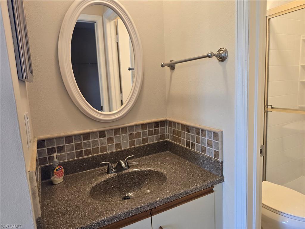 5741 Whitaker Road, Unit D203 Naples, FL 34112 - Photo 12 of 30 a bathroom with a sink and a mirror