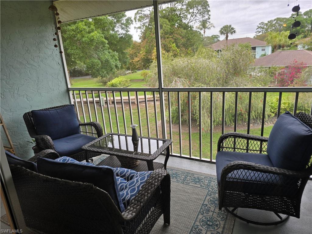5741 Whitaker Road, Unit D203 Naples, FL 34112 - Photo 13 of 21 Balcony with an outdoor lounge area overlooking pool area