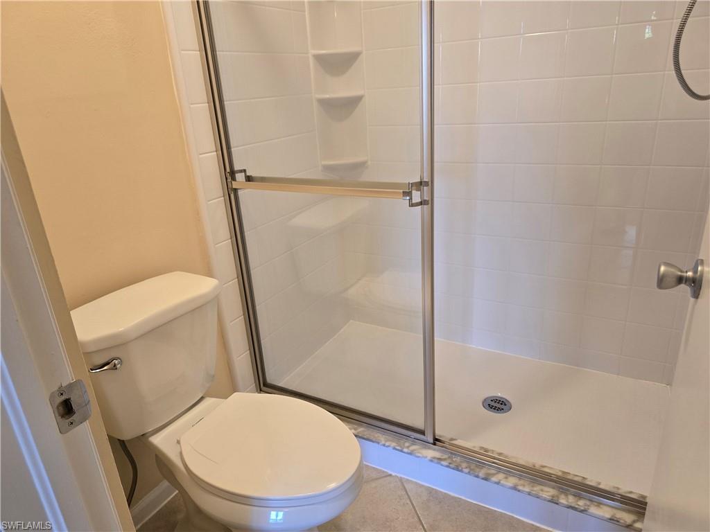 5741 Whitaker Road, Unit D203 Naples, FL 34112 - Photo 14 of 30 a white toilet sitting next to a bath tub