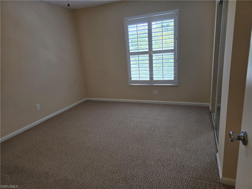 5741 Whitaker Road, Unit D203 Naples, FL 34112 - Photo 18 of 30 an empty room with a window