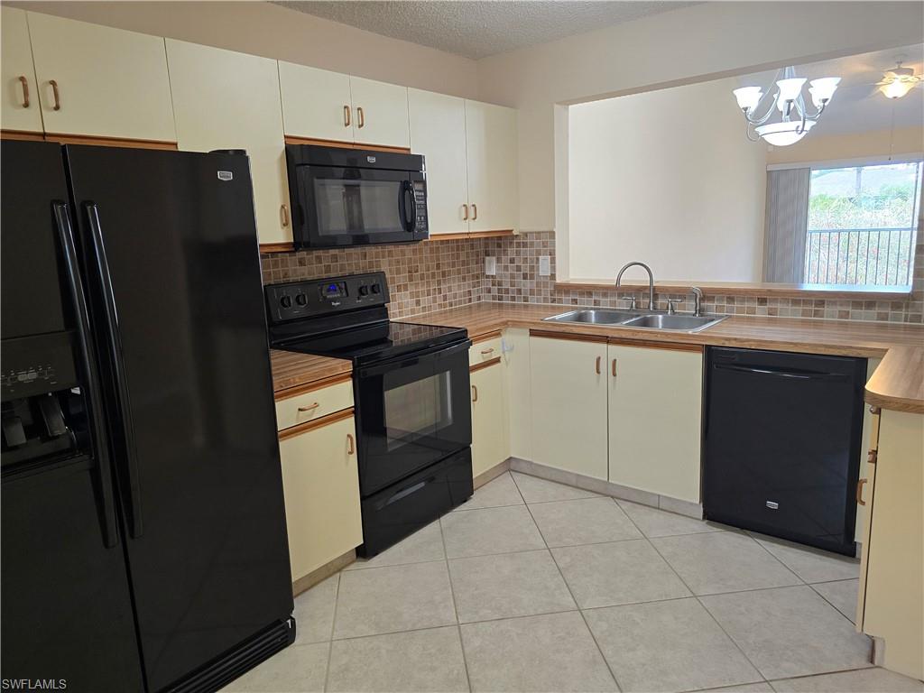 5741 Whitaker Road, Unit D203 Naples, FL 34112 - Photo 5 of 30 a kitchen with a sink stove and refrigerator