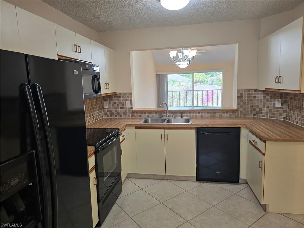 5741 Whitaker Road, Unit D203 Naples, FL 34112 - Photo 6 of 30 a kitchen with granite countertop a refrigerator and a sink