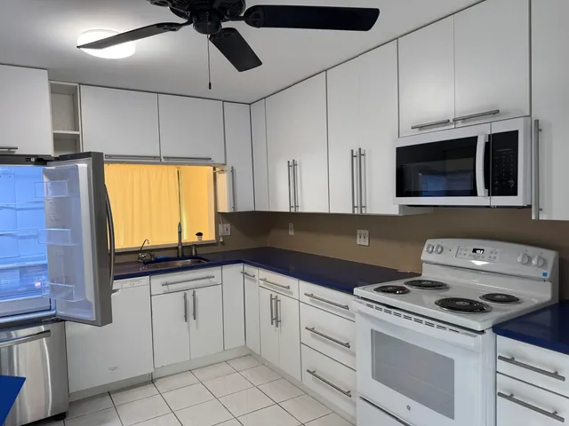a kitchen with granite countertop a sink a stove and microwave
