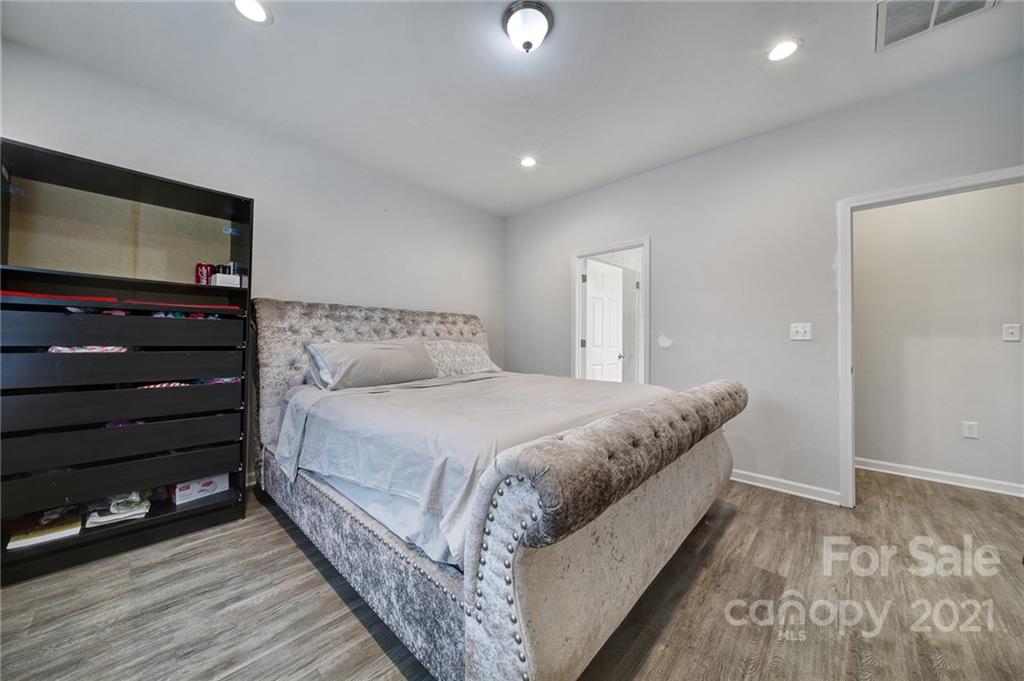 5040 Cheviot Road Charlotte, NC 28269 - Photo 15 of 27 a bedroom with a bed and wooden floor