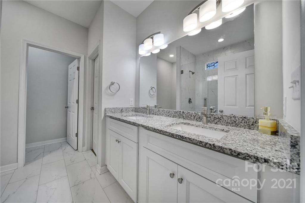 5040 Cheviot Road Charlotte, NC 28269 - Photo 16 of 27 a bathroom with a granite countertop sink and a mirror