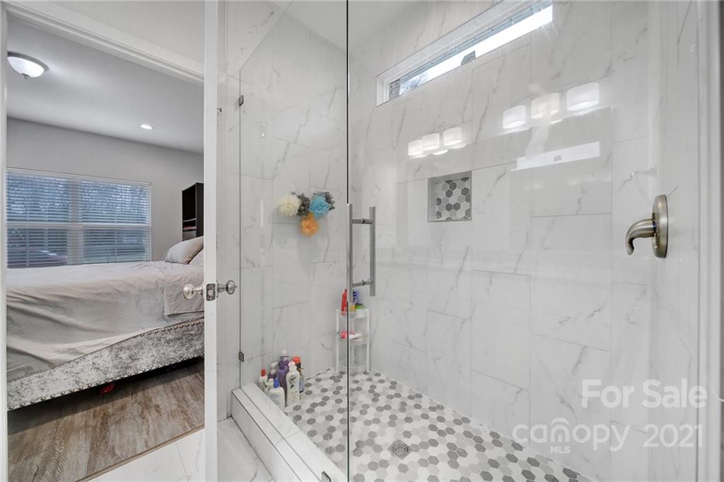 5040 Cheviot Road Charlotte, NC 28269 - Photo 17 of 27 a bathroom with a granite countertop shower a sink and a mirror