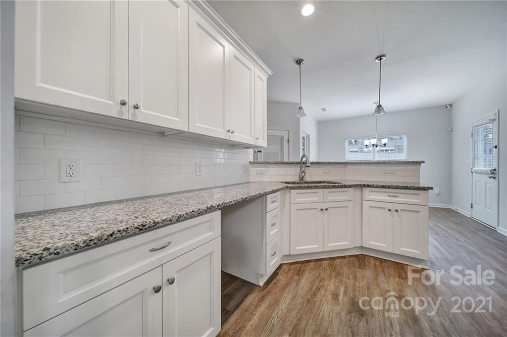 5040 Cheviot Road Charlotte, NC 28269 - Photo 3 of 27 a kitchen with granite countertop cabinets stainless steel appliances and wooden floor