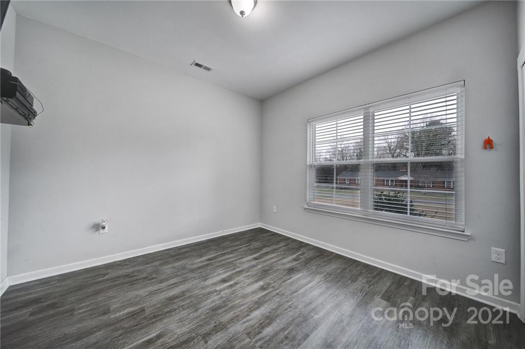 5040 Cheviot Road Charlotte, NC 28269 - Photo 21 of 27 a view of an empty room with wooden floor and a window