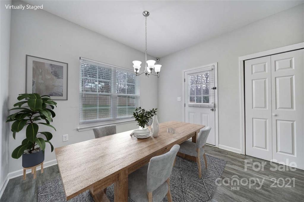 5040 Cheviot Road Charlotte, NC 28269 - Photo 7 of 27 a dining room with furniture potted plants and wooden floor