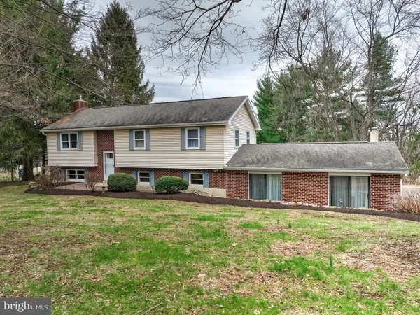 a front view of house with yard and trees around