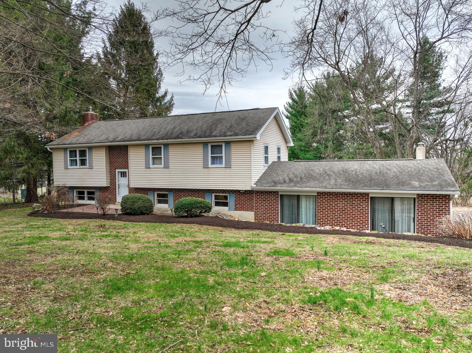 a front view of house with yard and trees around