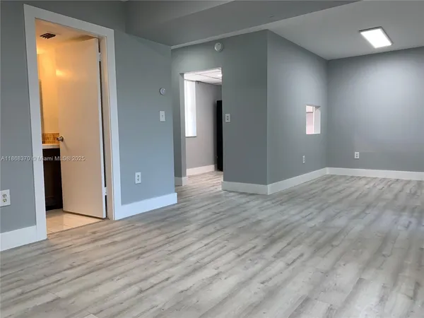 an empty room with wooden floor and a window