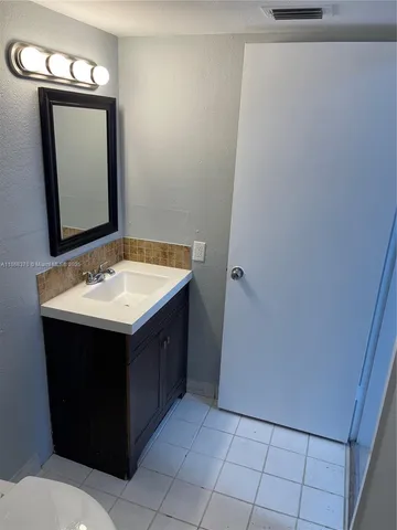 a bathroom with a sink vanity and a mirror