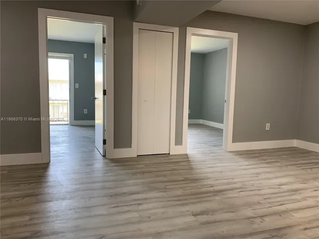 an empty room with wooden floor and closet