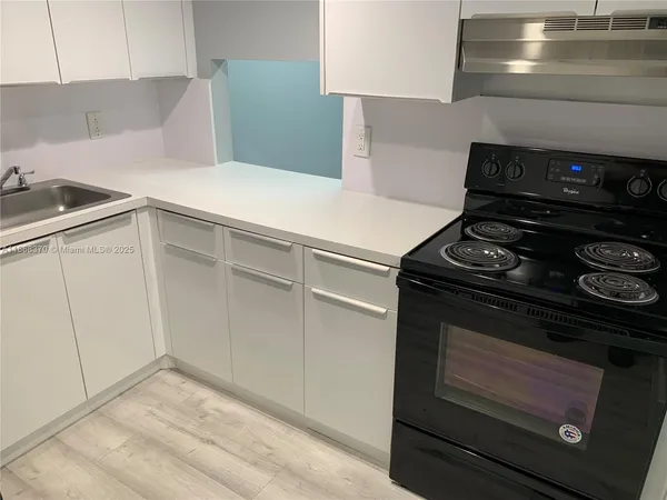 a kitchen with a stove and white cabinets