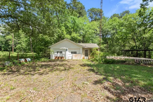a large yard with lots of green space and house in the back