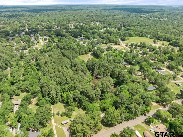an aerial view of residential house with outdoor space and trees all around