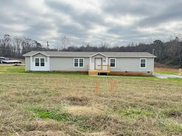 a view of a house with a big yard and large trees
