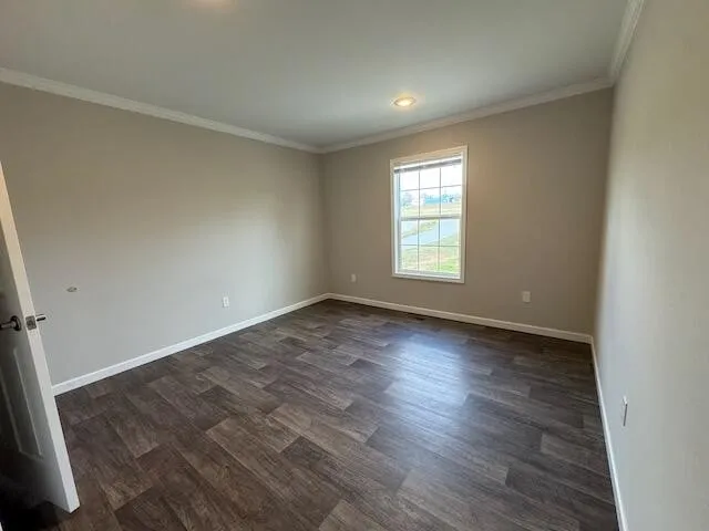 an empty room with wooden floor and window