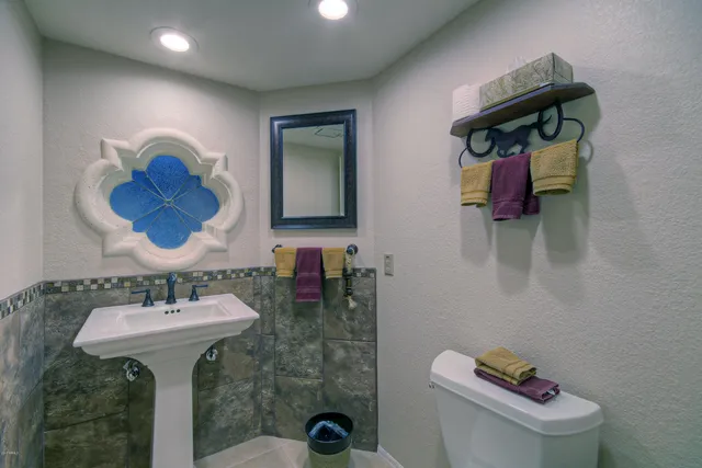 a bathroom with a sink mirror and toilet
