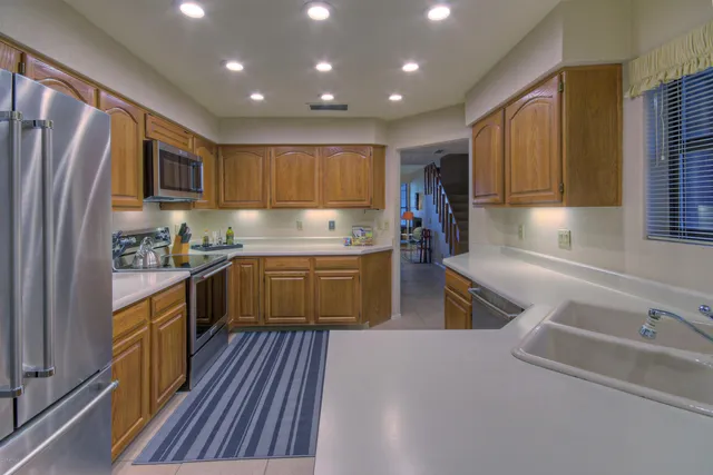 a kitchen with a sink appliances cabinets and a counter top space