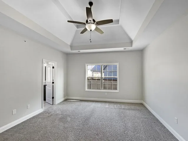 an empty room with a window and a ceiling fan