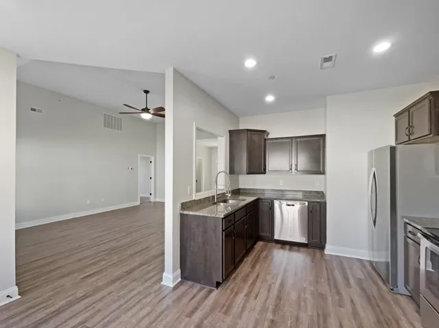 a kitchen with stainless steel appliances granite countertop a sink stove and refrigerator