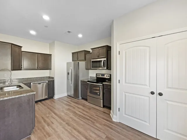 a kitchen with stainless steel appliances a refrigerator stove and sink