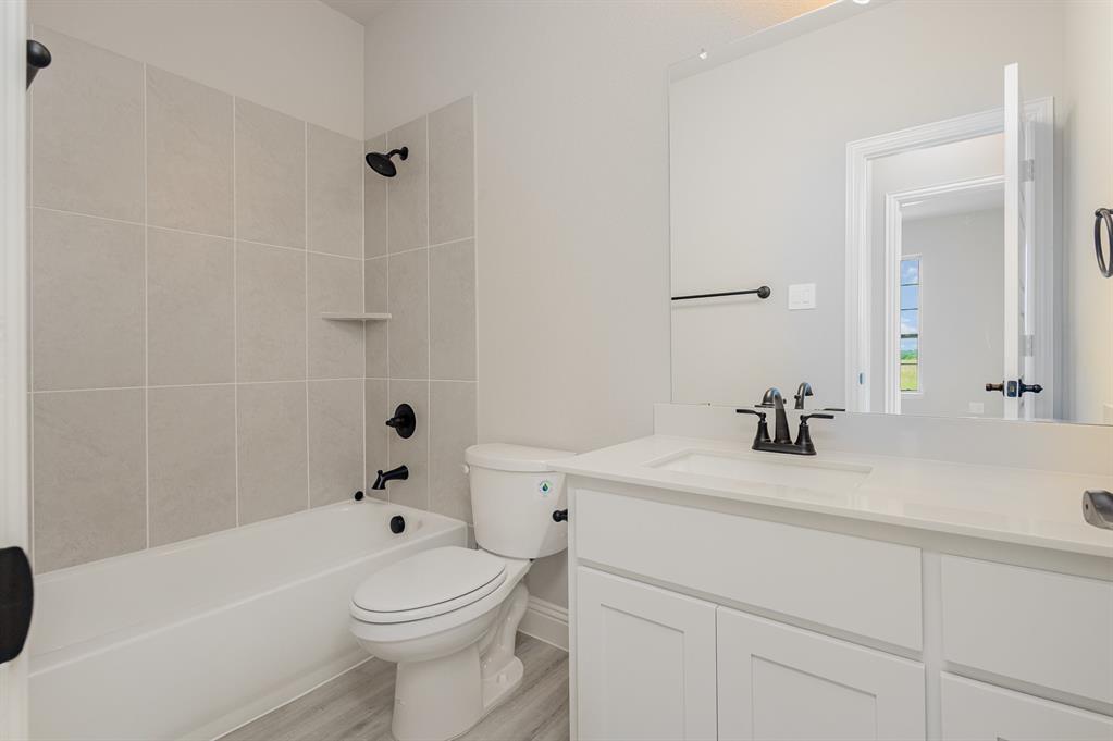 3613 Geoffrey Trail Rowlett, TX 75088 - Photo 13 of 13 Bathroom with washtub / shower combination, vanity, and light wood finished floors