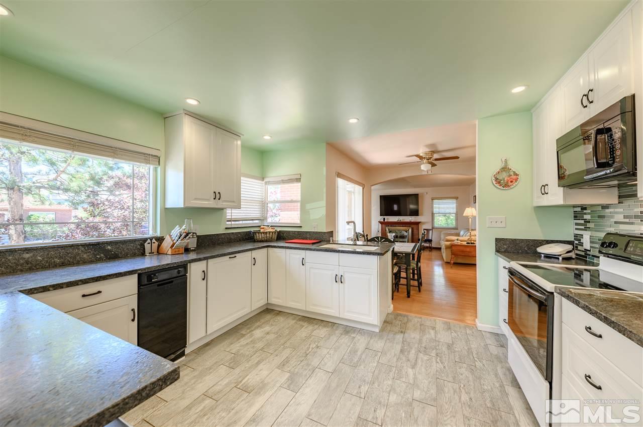 705 East Taylor Street Reno, NV 89502 - Photo 8 of 20 a large kitchen with stainless steel appliances granite countertop a stove top oven a sink dishwasher a dining table and chairs with wooden floor