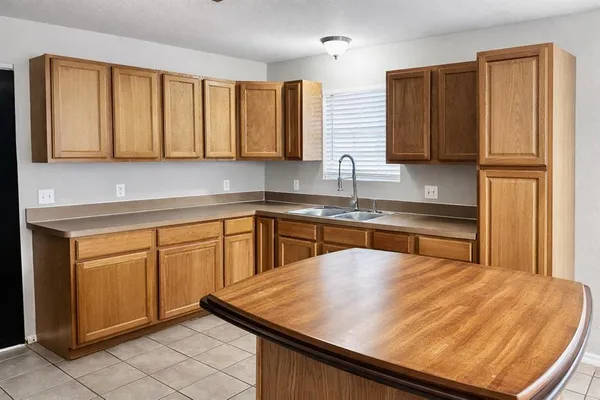 a kitchen with stainless steel appliances granite countertop a sink window and cabinets