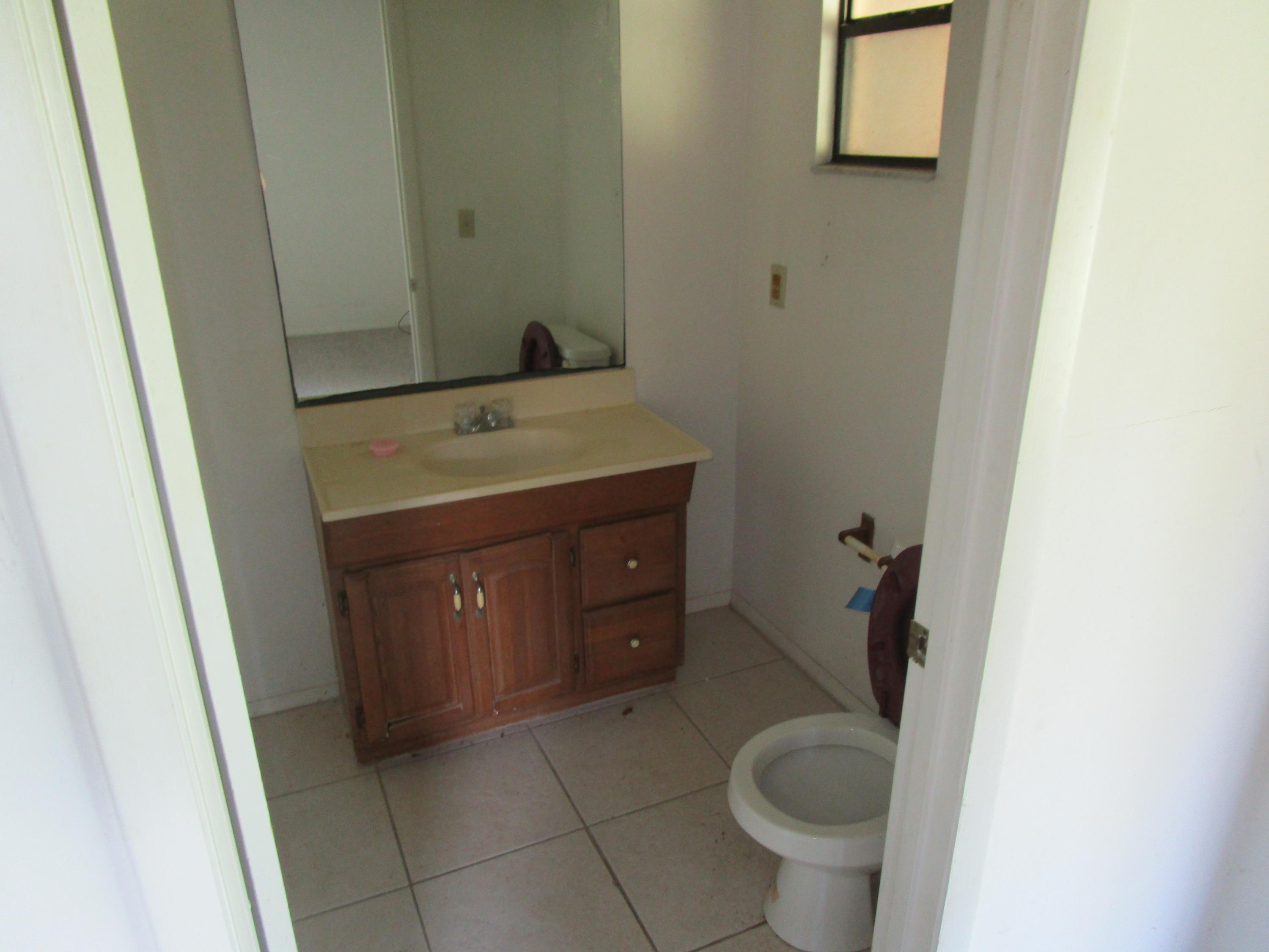 6302 Indrio Road Fort Pierce, FL 34951 - Photo 7 of 25 a bathroom with a granite countertop toilet and a sink