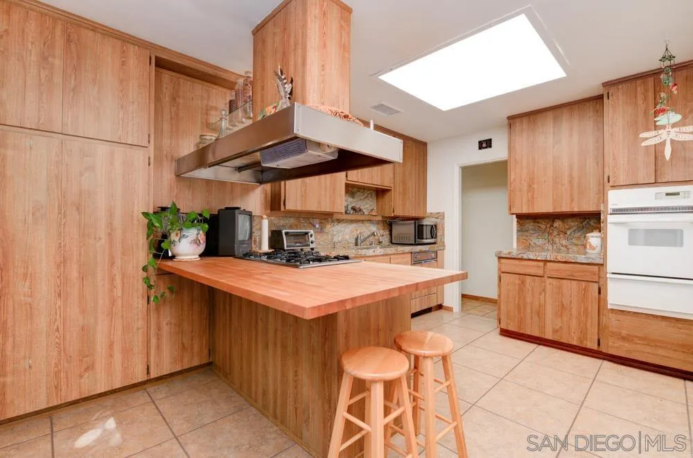 4470 Monahan Road La Mesa, CA 91941 - Photo 7 of 26 a kitchen with stainless steel appliances a sink a stove a refrigerator and cabinets