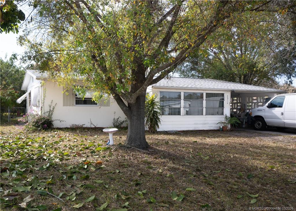 2314 Southeast Washington Street Stuart, FL 34997 - Photo 1 of 16 a white house that has a tree in front of it