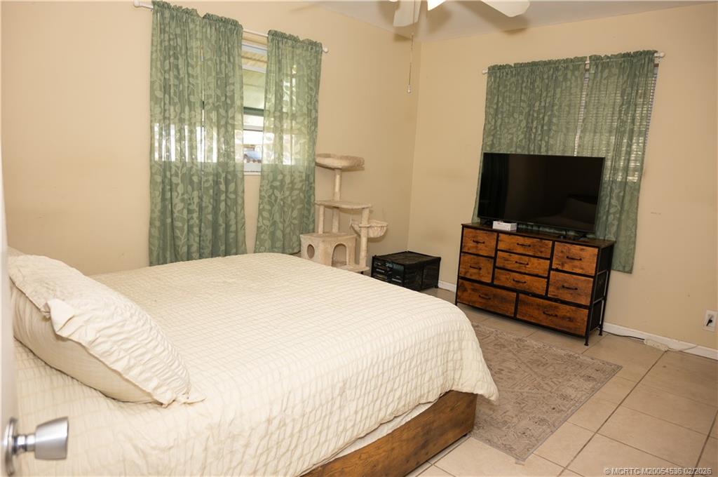 2314 Southeast Washington Street Stuart, FL 34997 - Photo 14 of 16 a bedroom with a bed and a flat screen tv