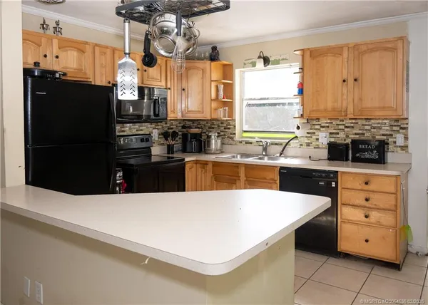 a kitchen with stainless steel appliances kitchen island granite countertop a refrigerator and a stove top oven