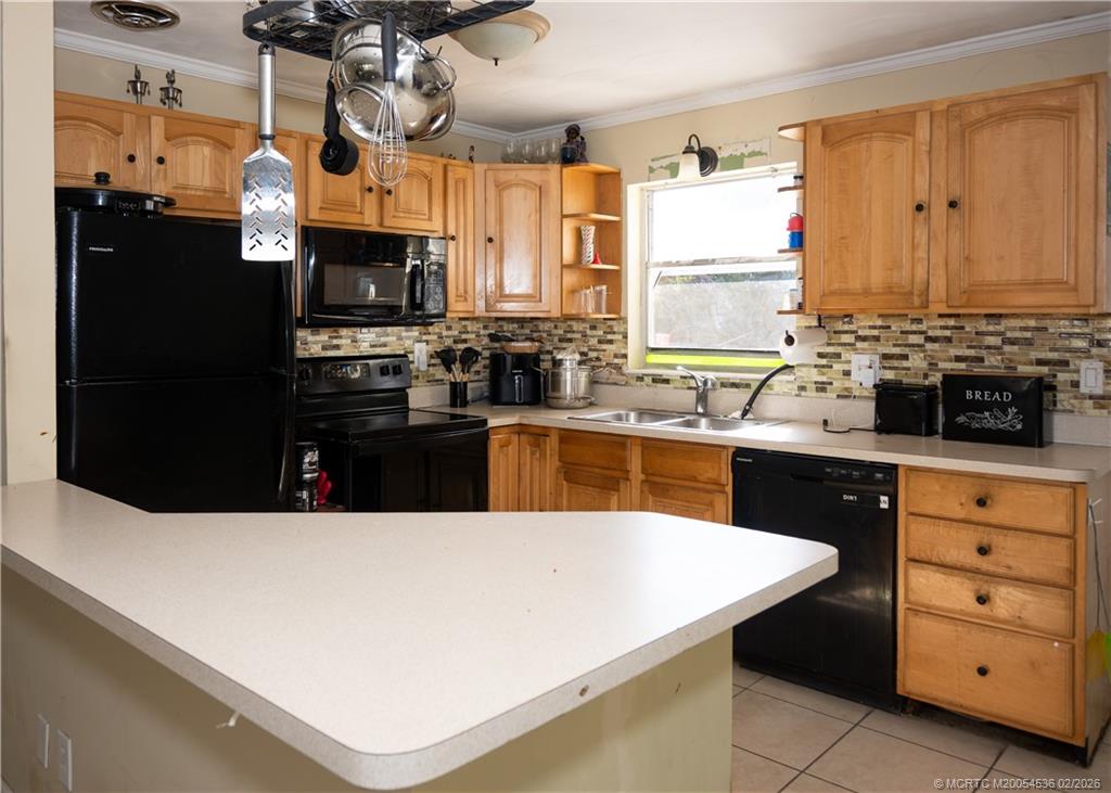 2314 Southeast Washington Street Stuart, FL 34997 - Photo 10 of 16 a kitchen with stainless steel appliances a stove a refrigerator a sink a dining table and chairs
