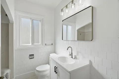 a bathroom with a toilet sink and mirror