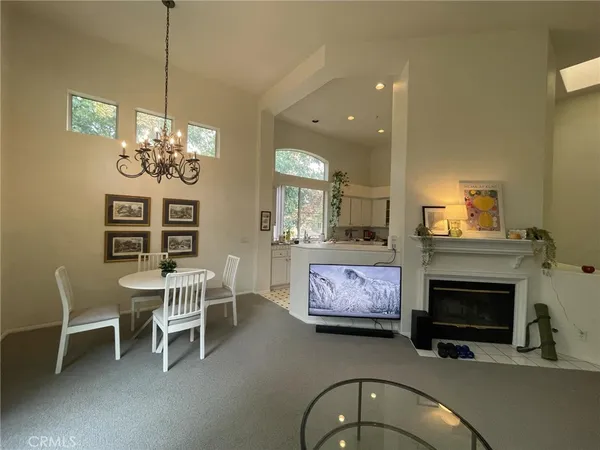 a living room with furniture a fireplace and a chandelier