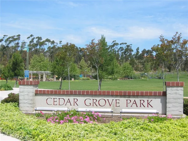 a view of sign board with a house in the background