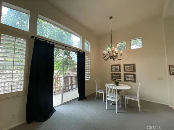 a dining room with furniture a chandelier and window