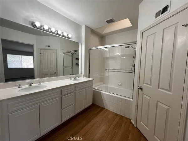 a bathroom with a tub a double vanity sink double and mirror