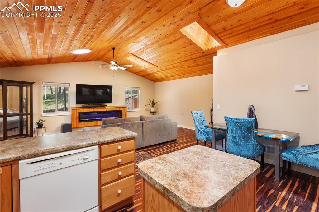 234 Wahsatch Road Florissant, CO 80816 - Photo 16 of 44 a kitchen with stainless steel appliances kitchen island granite countertop a table chairs in it and a wooden floor