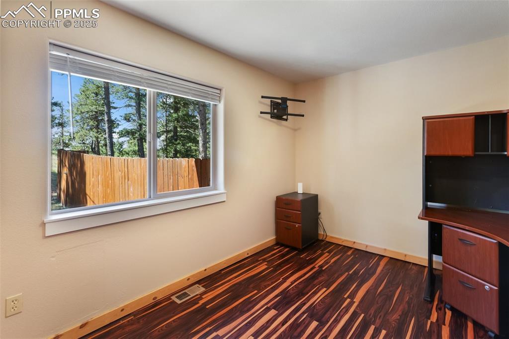 234 Wahsatch Road Florissant, CO 80816 - Photo 23 of 44 a bedroom with a bed and wooden floor