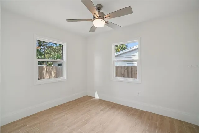 an empty room with a window and a fan