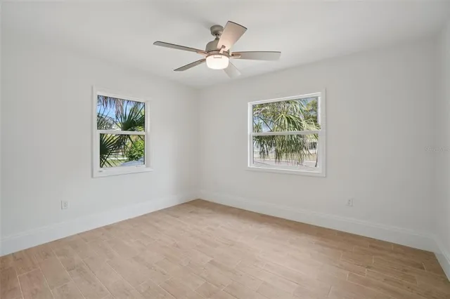 an empty room with windows and fan