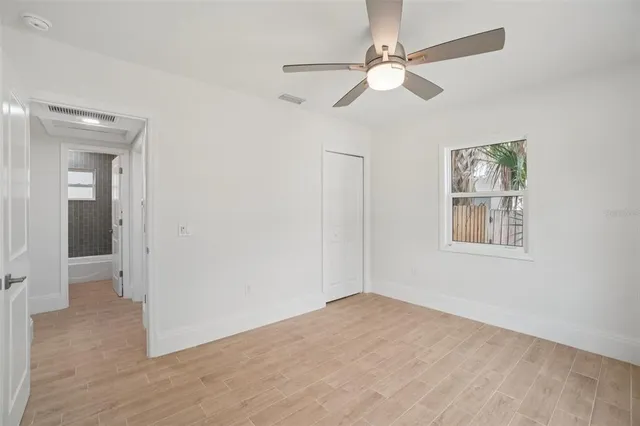 an empty room with fan and windows